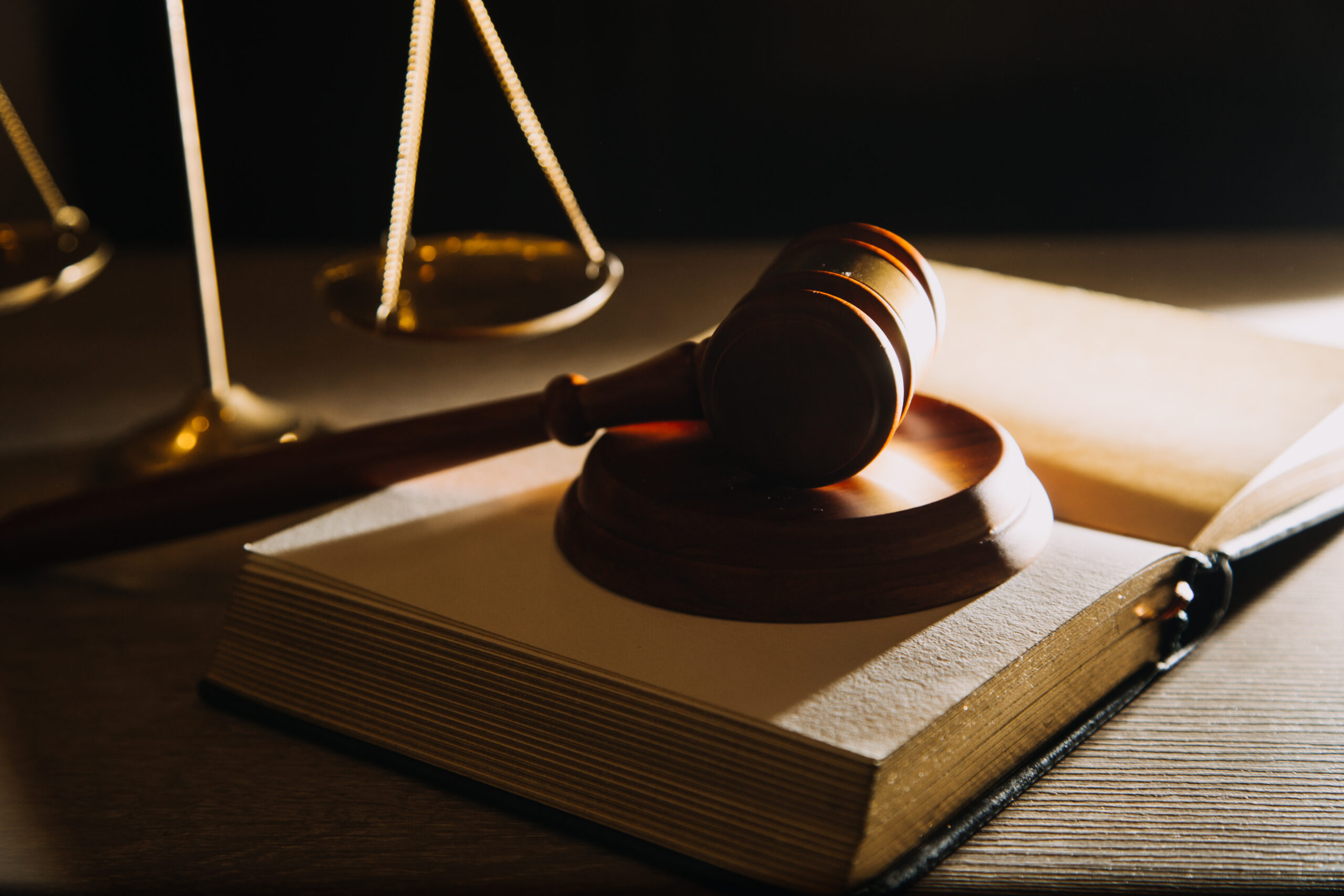 Business and lawyers discussing contract papers with brass scale