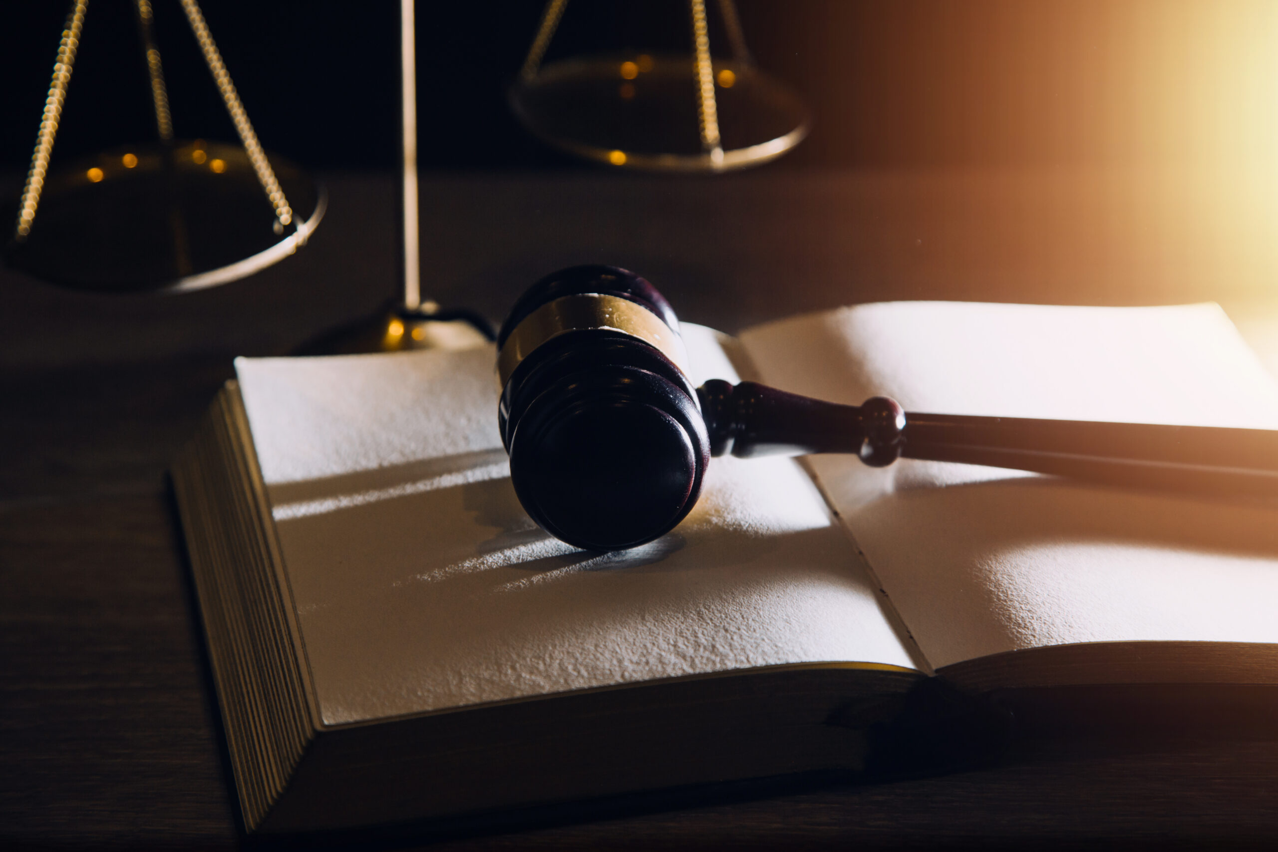 Business and lawyers discussing contract papers with brass scale