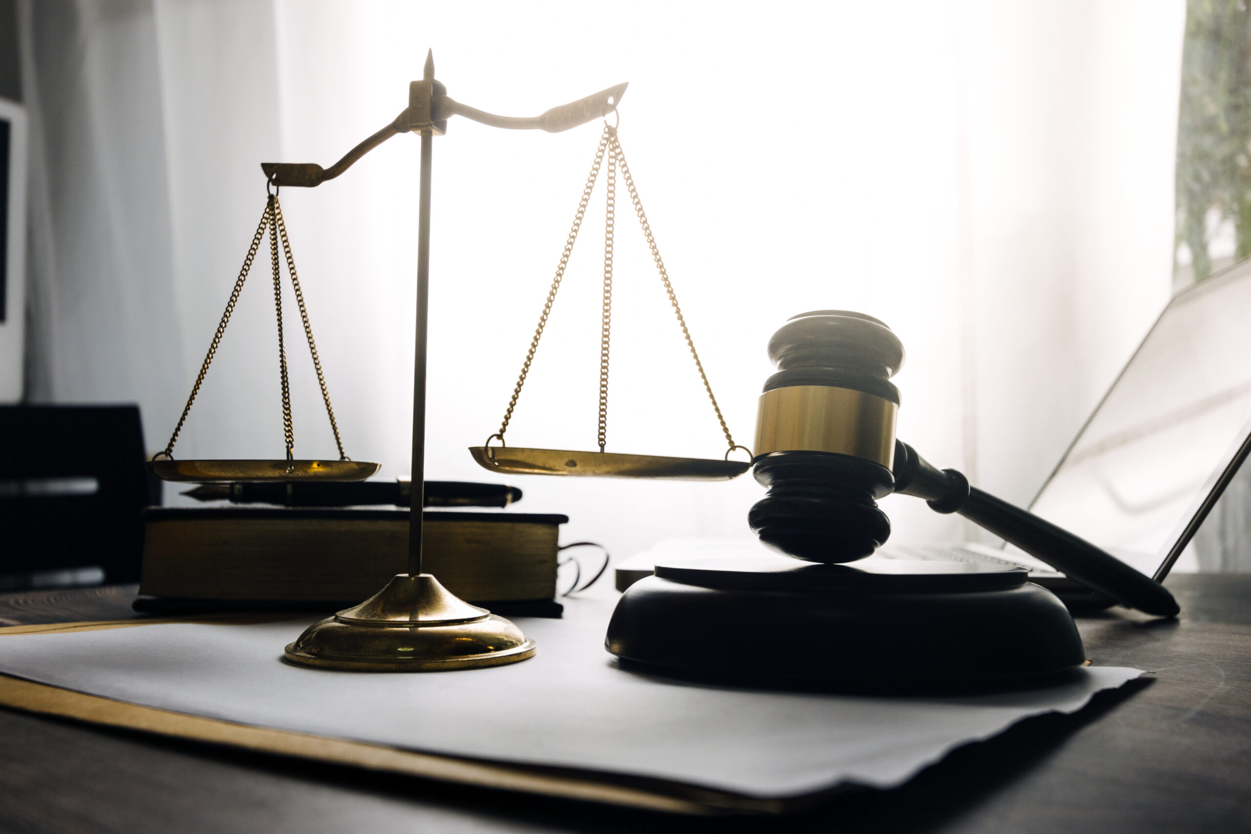 Business and lawyers discussing contract papers with brass scale