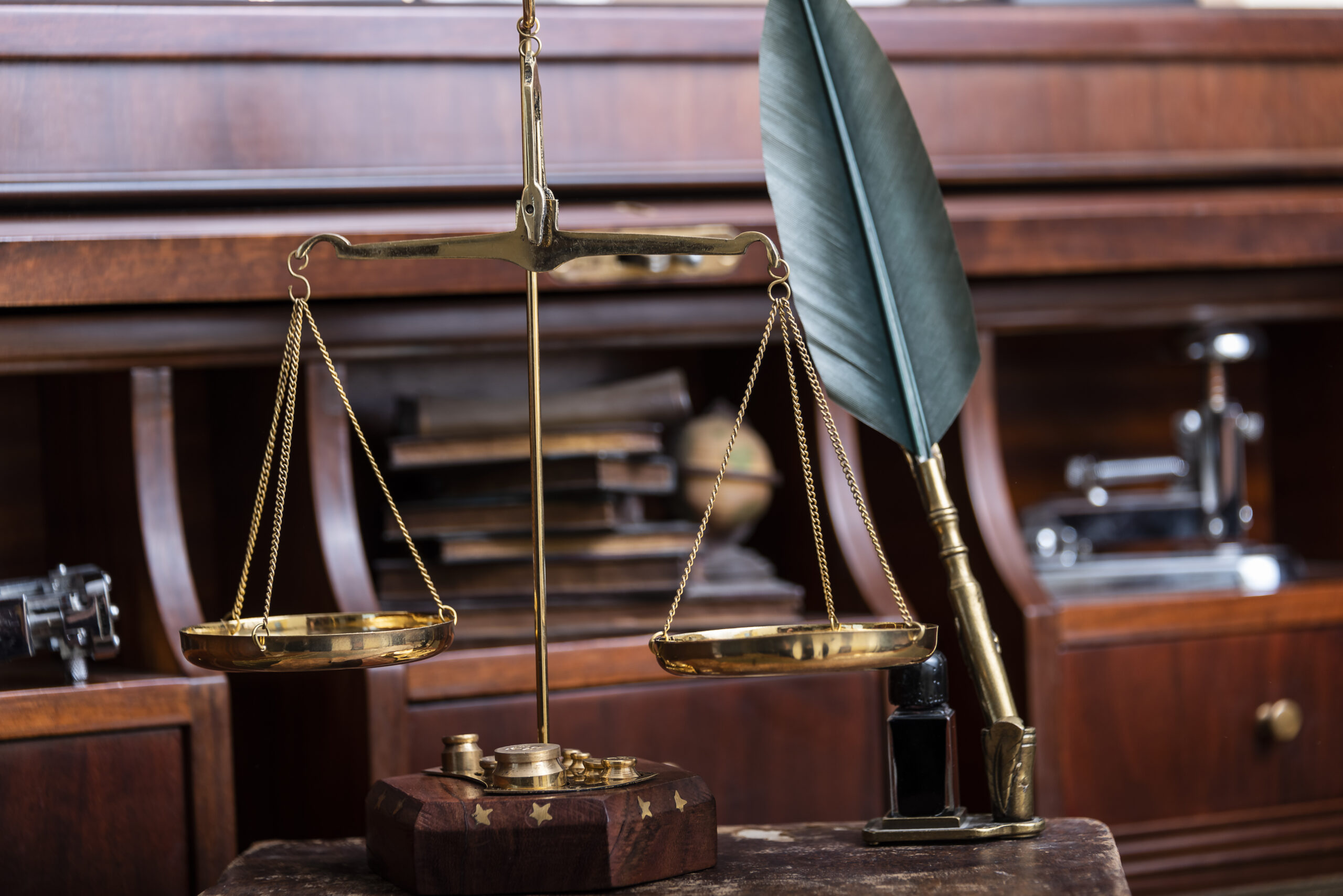 Scales of justice with law books on table of notary public in office.